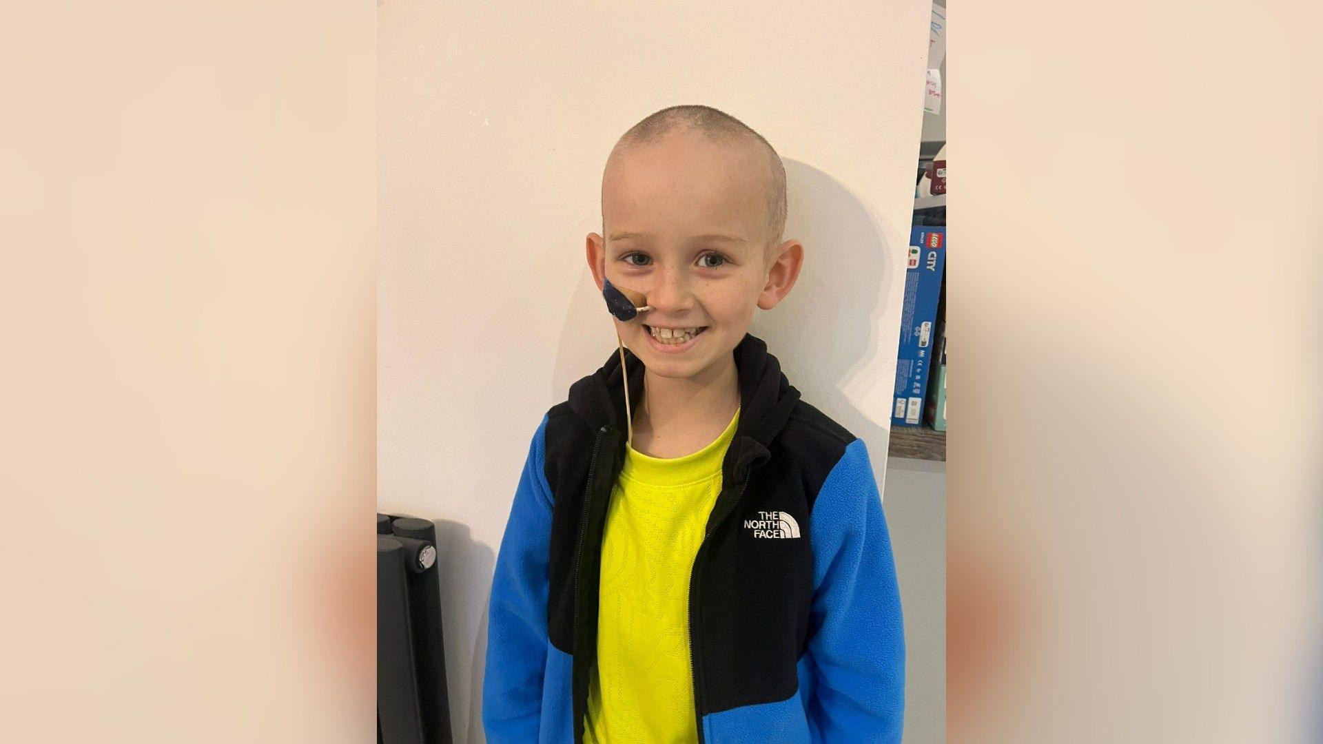 Oliver Stephenson smiling wearing a yellow tshirt and black and blue hoody