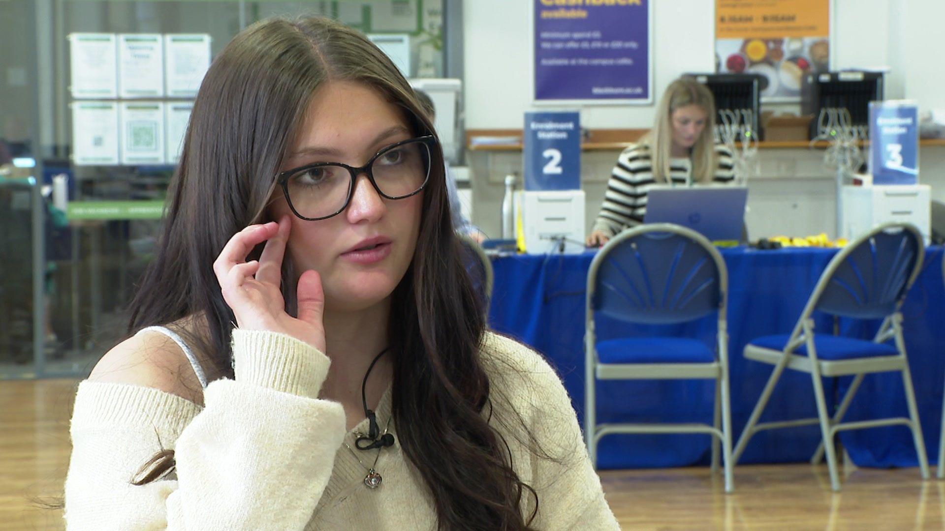 Daisy, with with long, dark hair and wearing black glasses and a white jumper, speaks about her experiences during lockdown