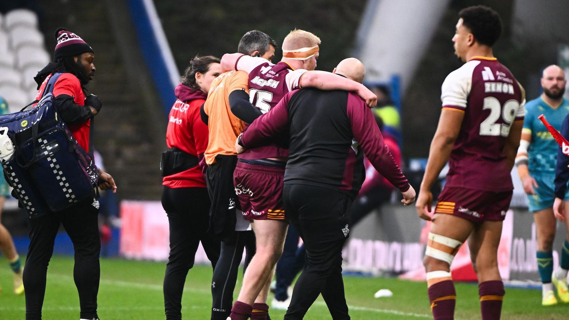 Matty English is helped from the field during Huddersfield Giants' game against Hull KR this season