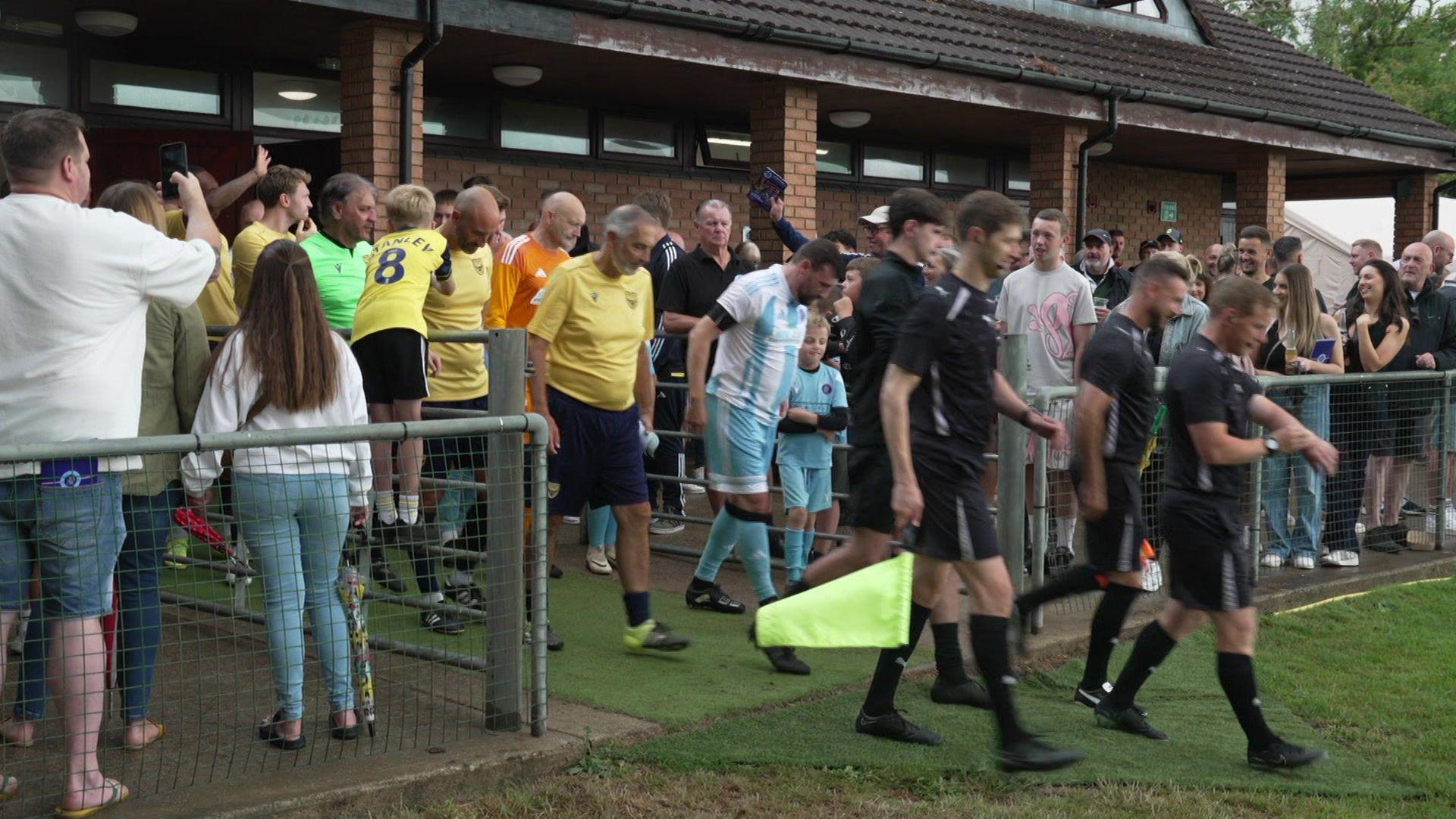 The two teams walk out behind a team of officials.