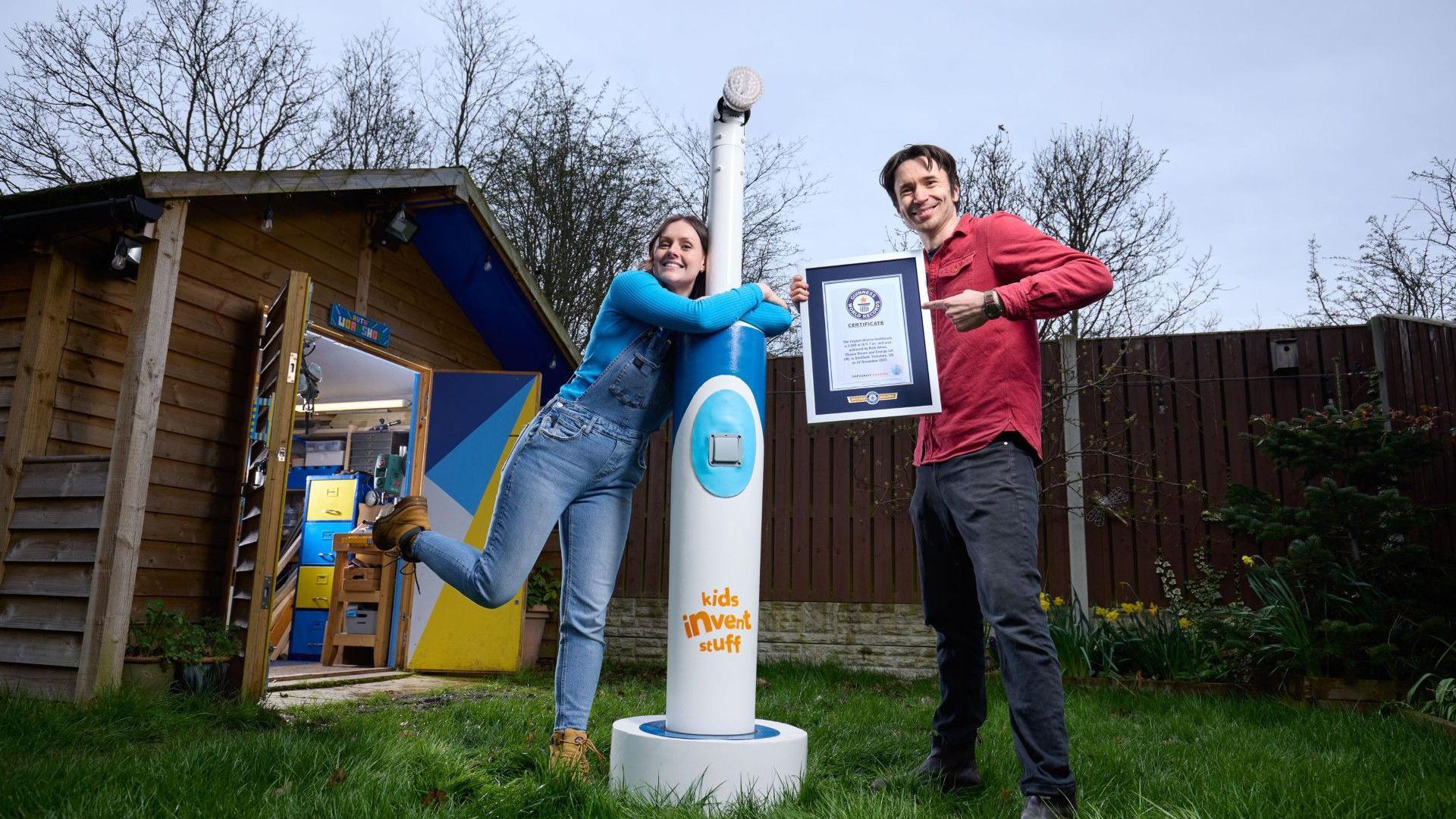 People with the giant toothbrush and the Guinness certificate.