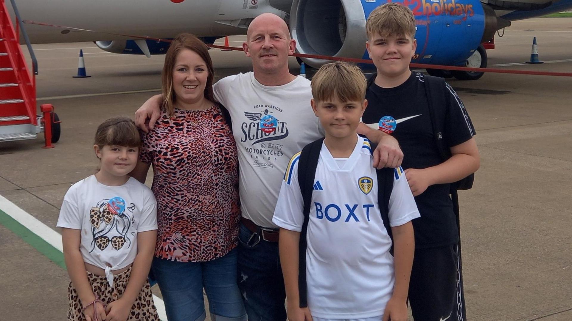 Amy Stevenson with her family pictured in front of a Jet2 Holidays plane