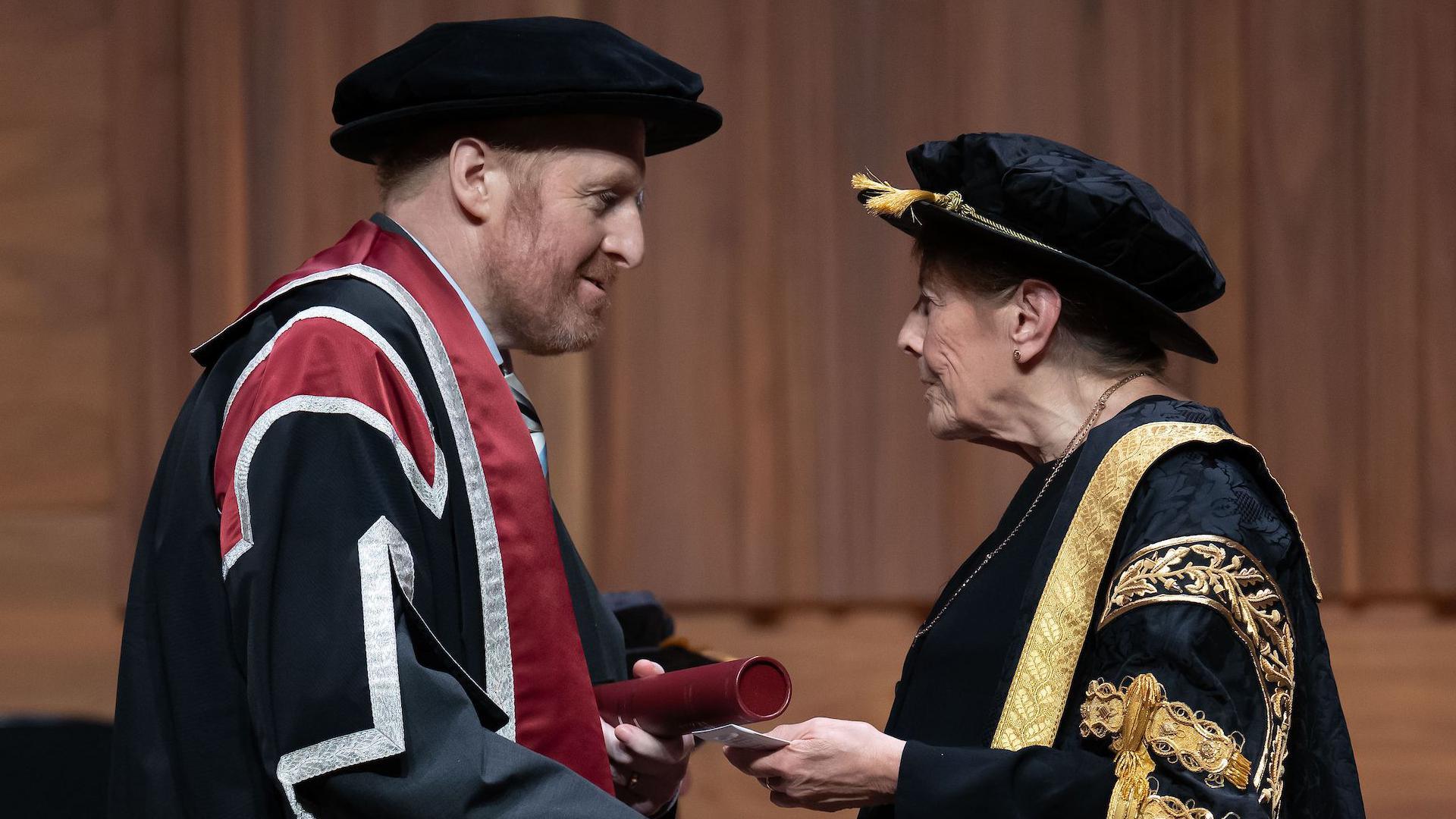 Tudur Hallam yn derbyn ei radd Doethur er Anrhydedd