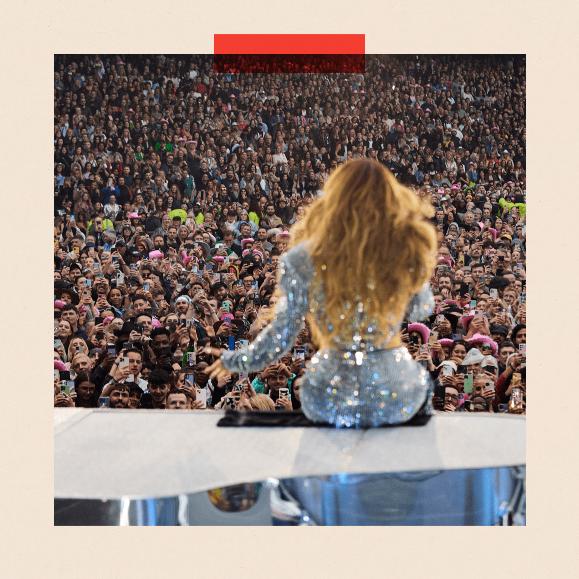 Beyonce sits on a piano in front of a large crowd