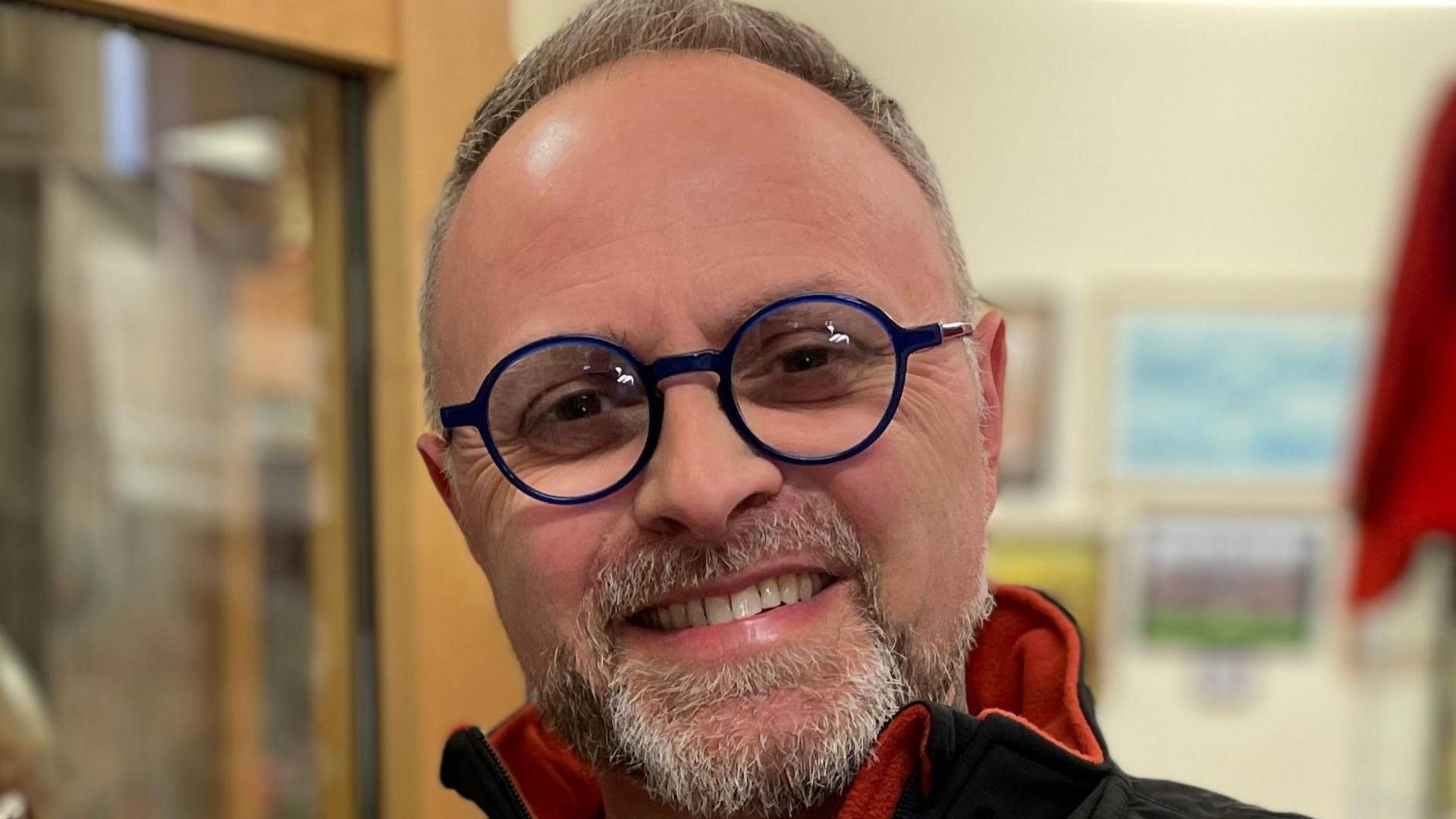 Tim Baker from the Ashbourne Historical Centre is pictured smiling with dark blue-rimmed glasses