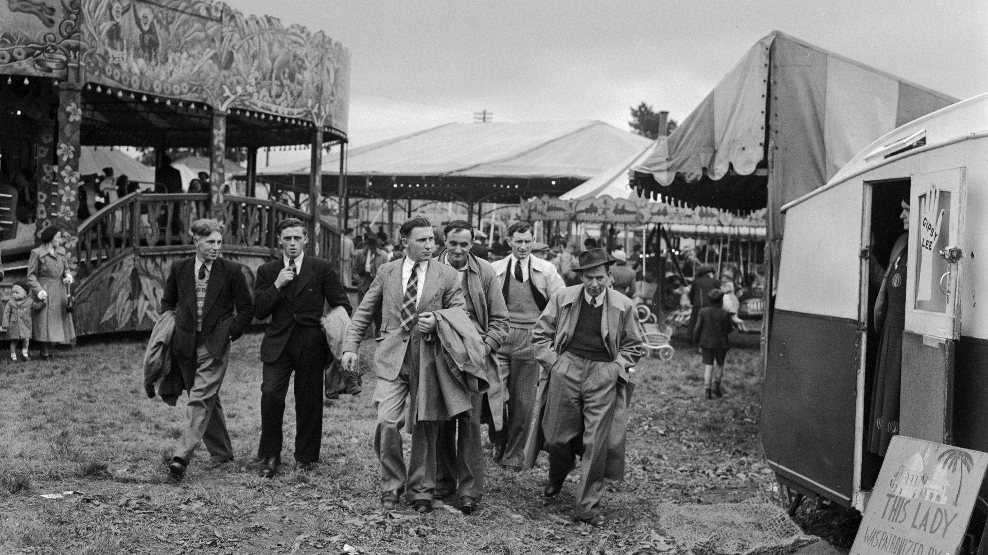 Criw o ddynion ifanc yn gadael adloniant y "ffair hwyl" ar y Grîn