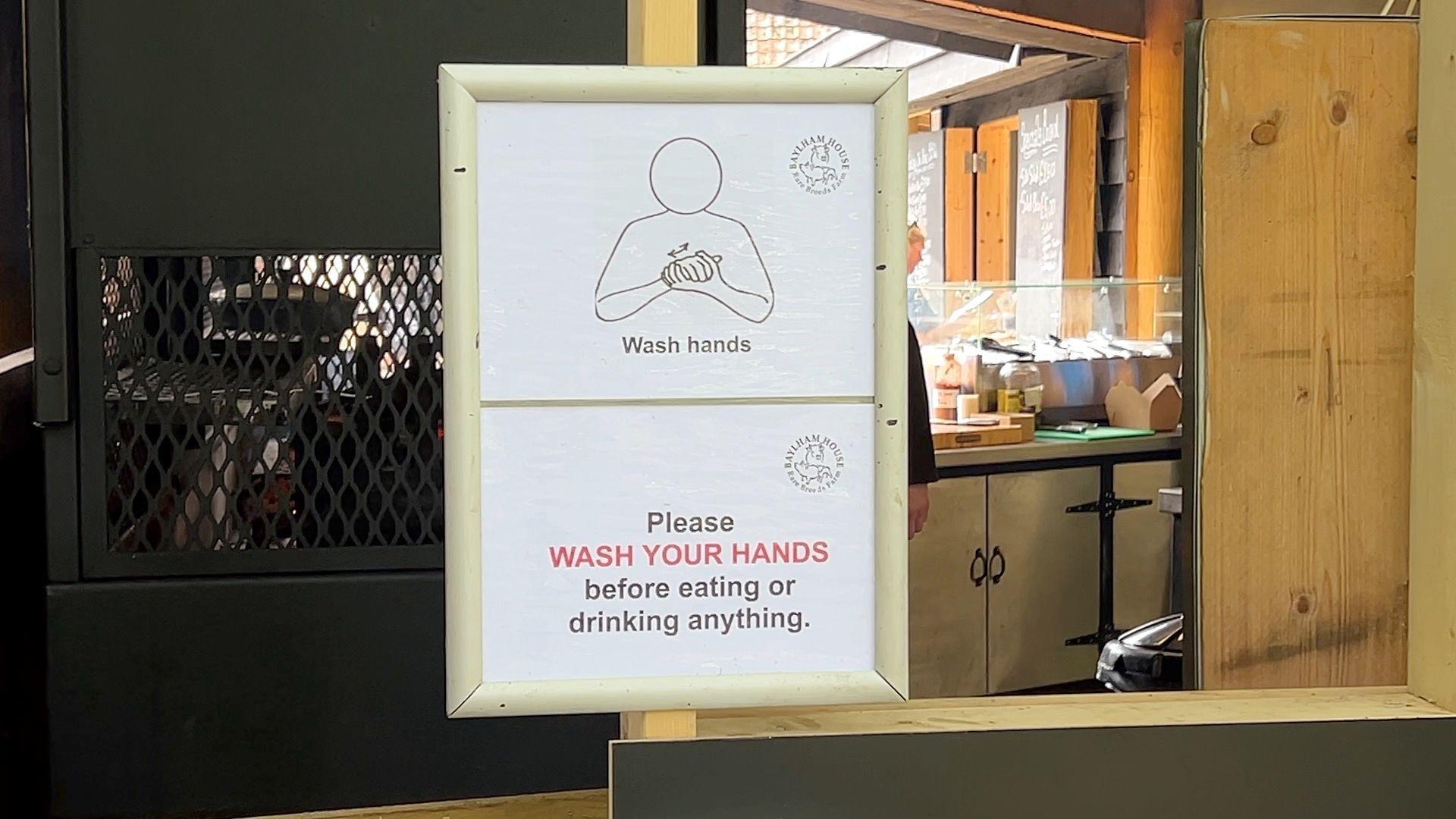 A sign reads: "Wash hands. Please wash your hands before eating or drinking anything."