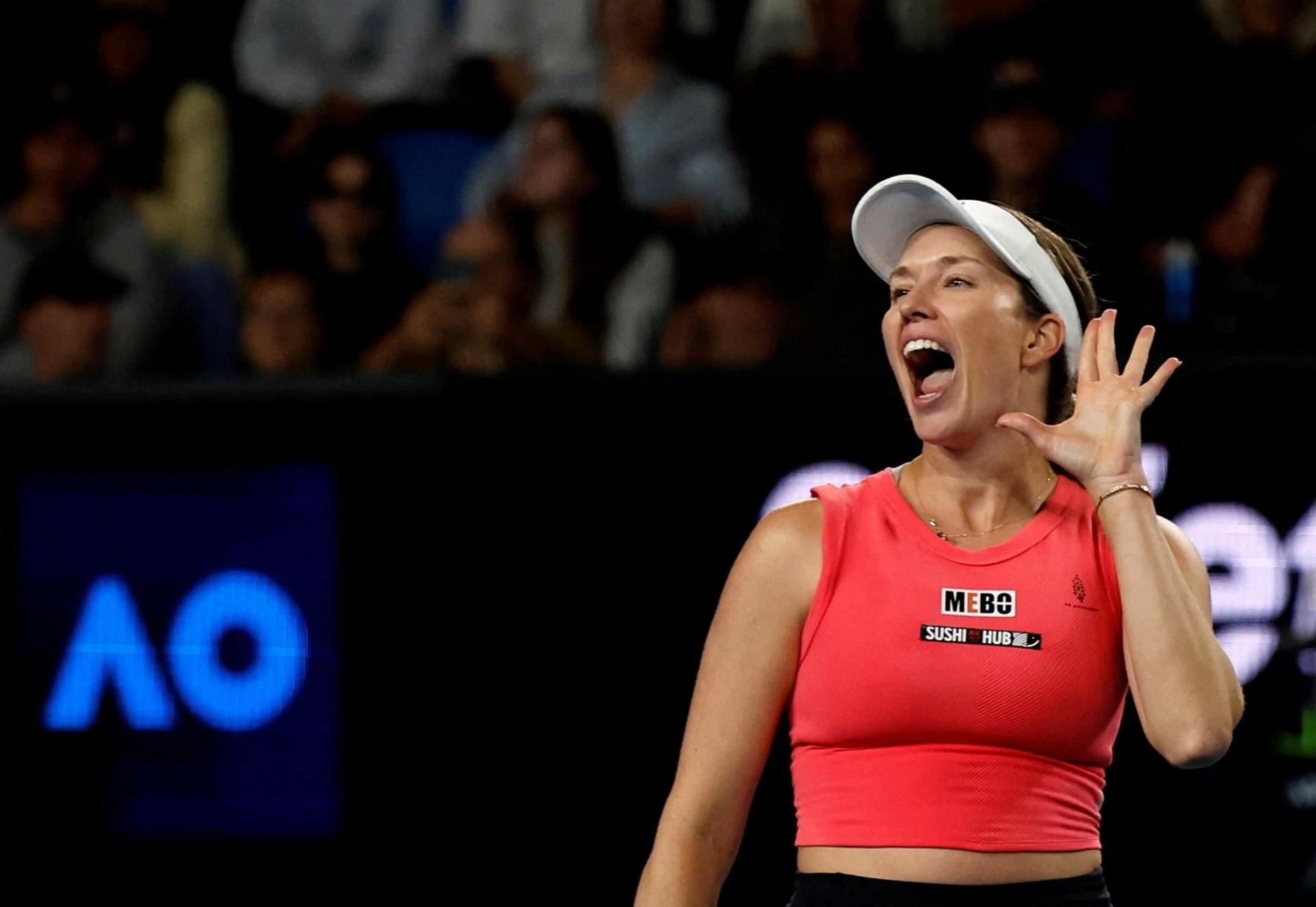 Danielle Collins cups her hand to her ears as she celebrates winning her tennis match