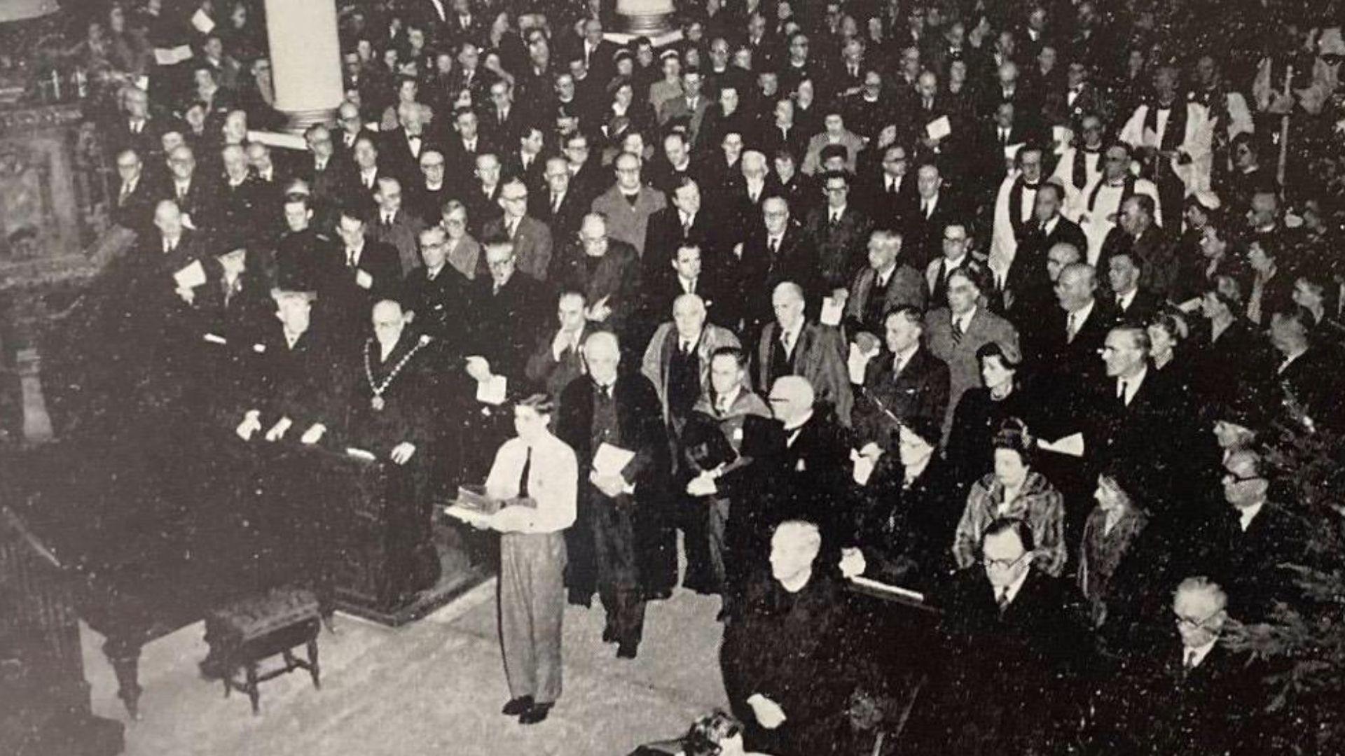 John Tudno Williams (mewn gwyn yn y blaen) yn cario Beibl William Morgan mewn gwasanaeth yn Llundain yn 1954