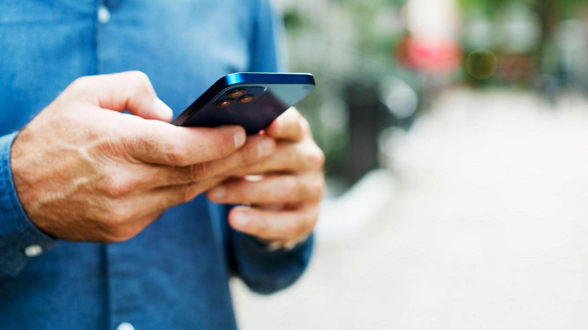 Generic image of a mans hands holding a phone