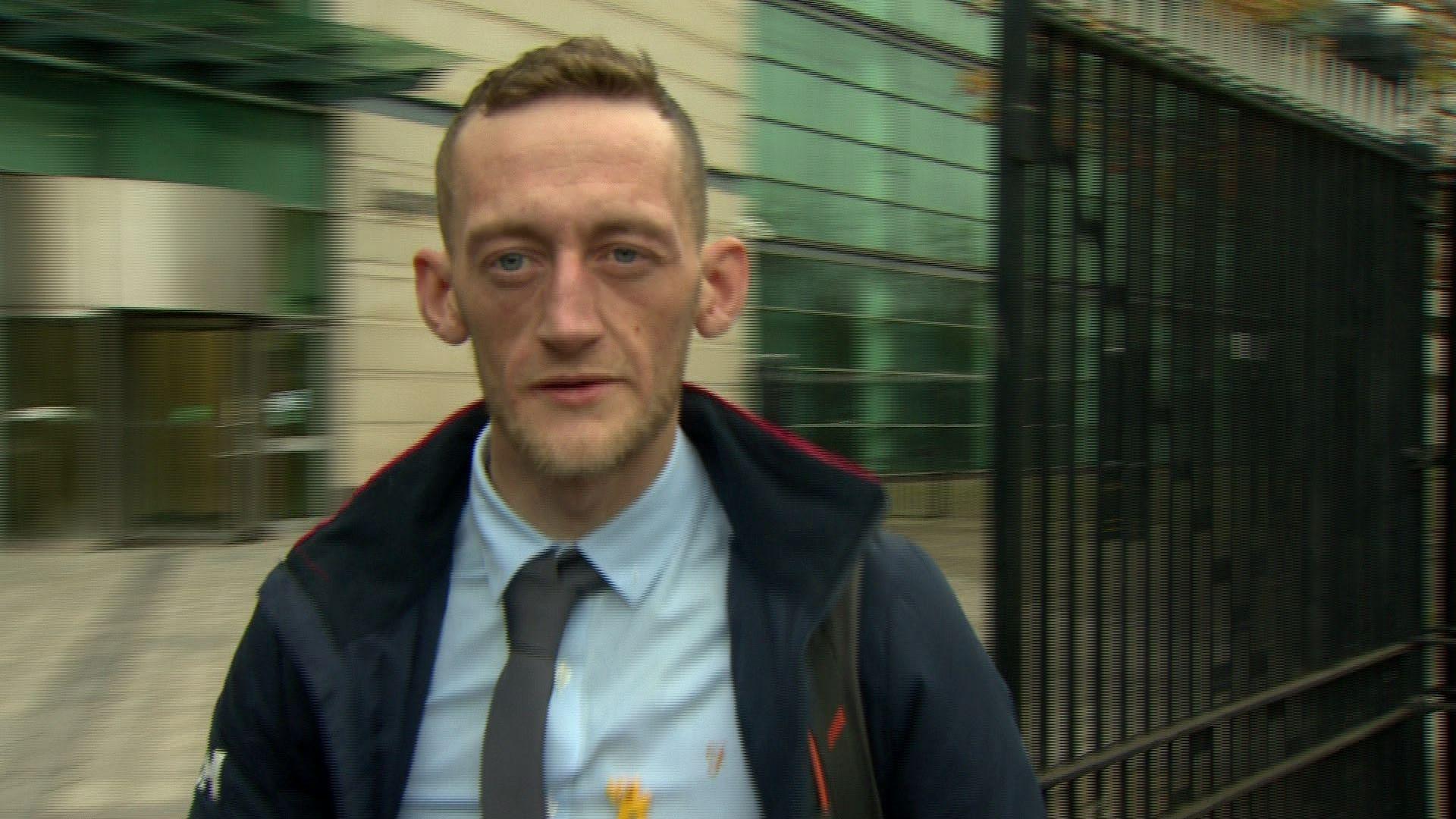 Craig Rowland has short fair hair and has stubble on his face.
He is wearing a blue shirt an grey tie and is seen outside Laganside Court in Belfast.