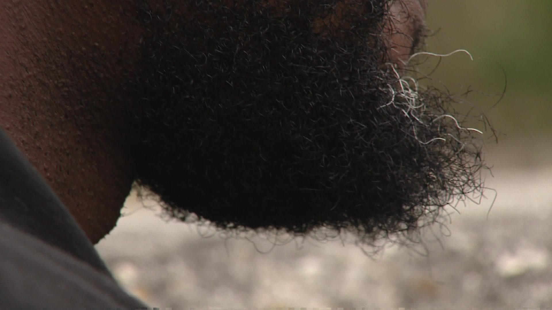 A close-up shot of Cedrick's black beard, filmed so as not to be immediately clear who he is 