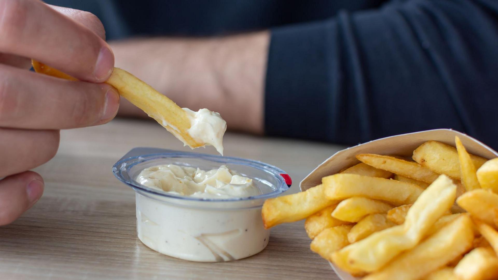 Man eating chips with a dip