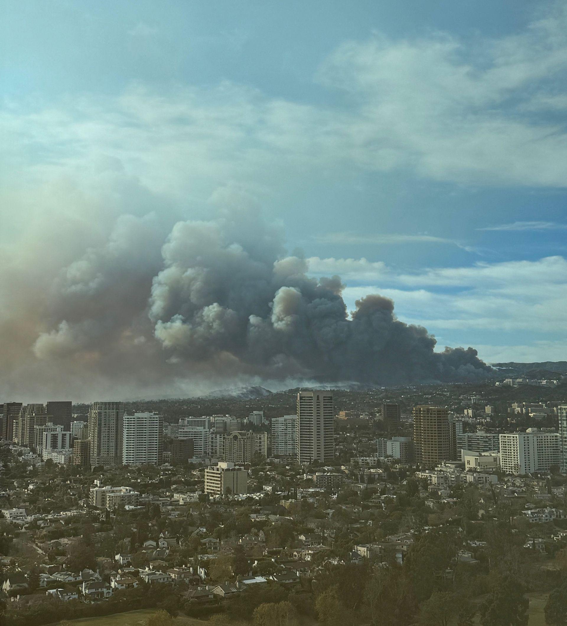 Thick smoke from the Palisades Fire rises over a wide view of Los Angeles on Wednesday.