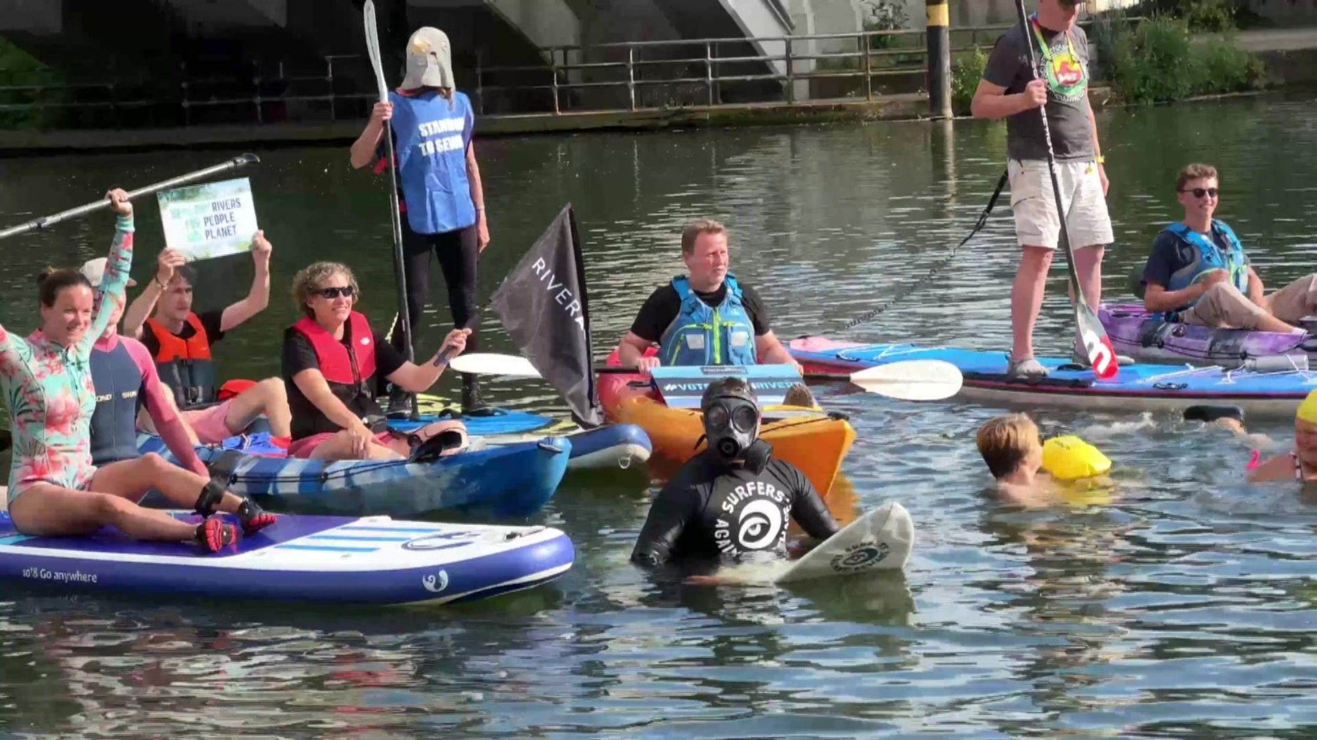 Protestors floating on paddleboards and surfboards or bobbing in the water