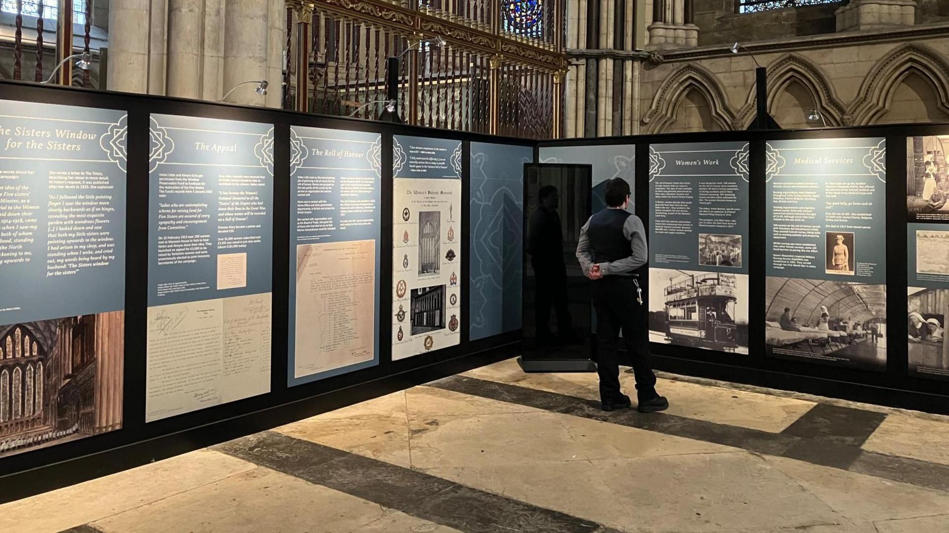 Man looking at exhibition display boards in York Minster