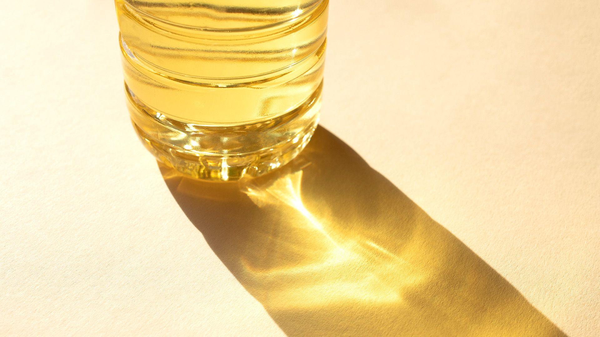 Bottle of sunflower oil on the beige background