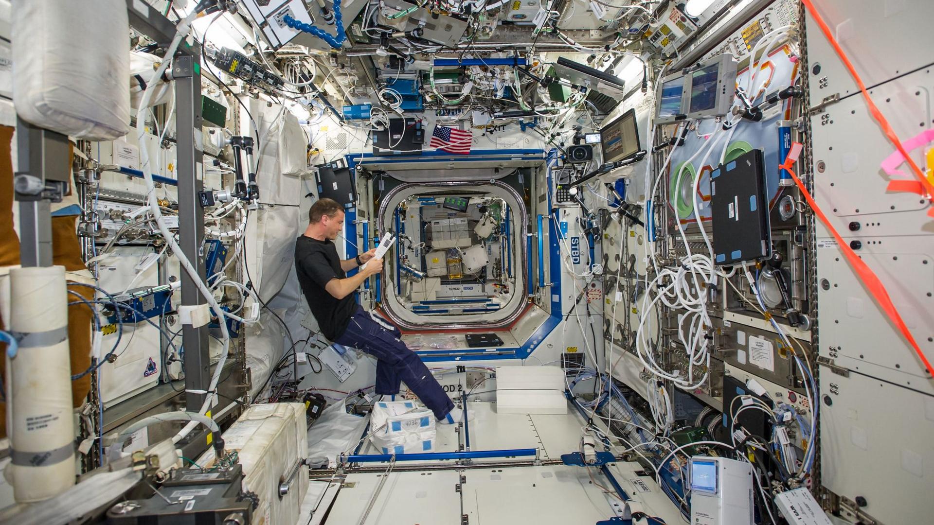 NASA astronaut Reid Wiseman, Expedition 40 flight engineer, reads a procedures checklist in the Destiny laboratory of the International Space Station.