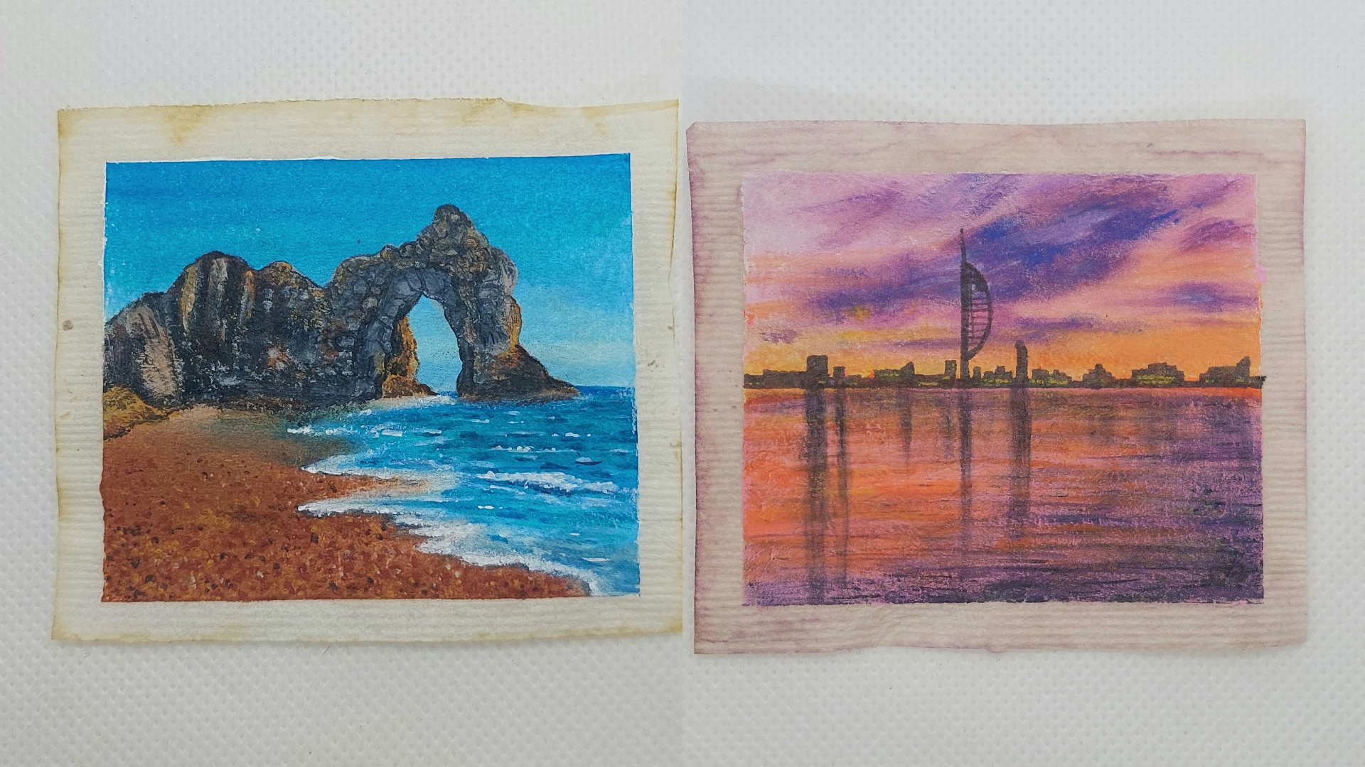 Two flat teabags, one has Durdle Door painted on, the other has the Spinnaker Tower painted