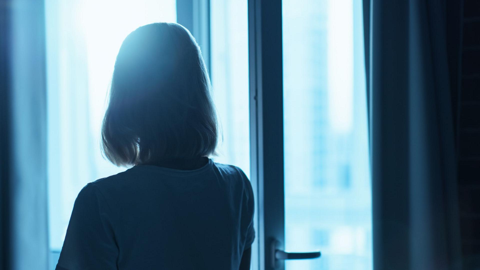 Woman silhouette in front of the window