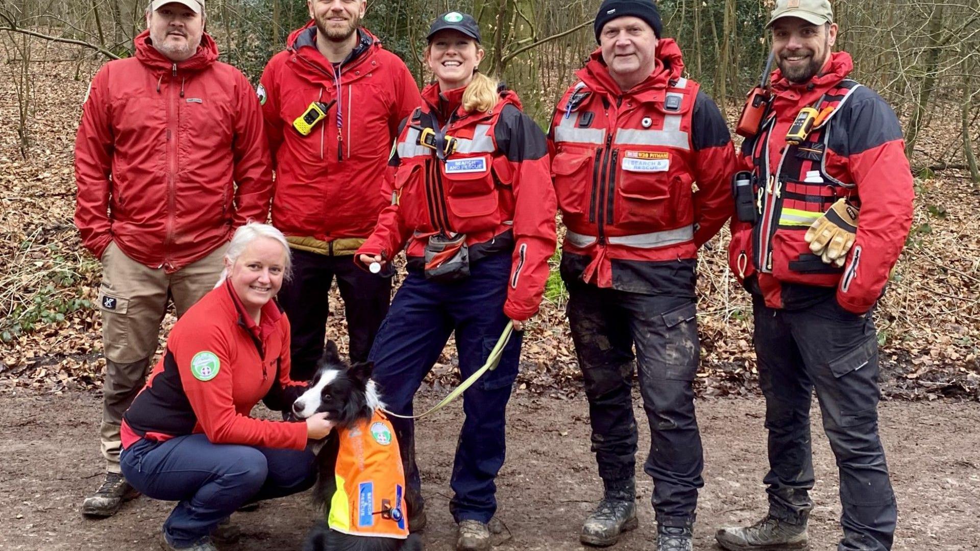 A search and rescue team with a black and white dog 