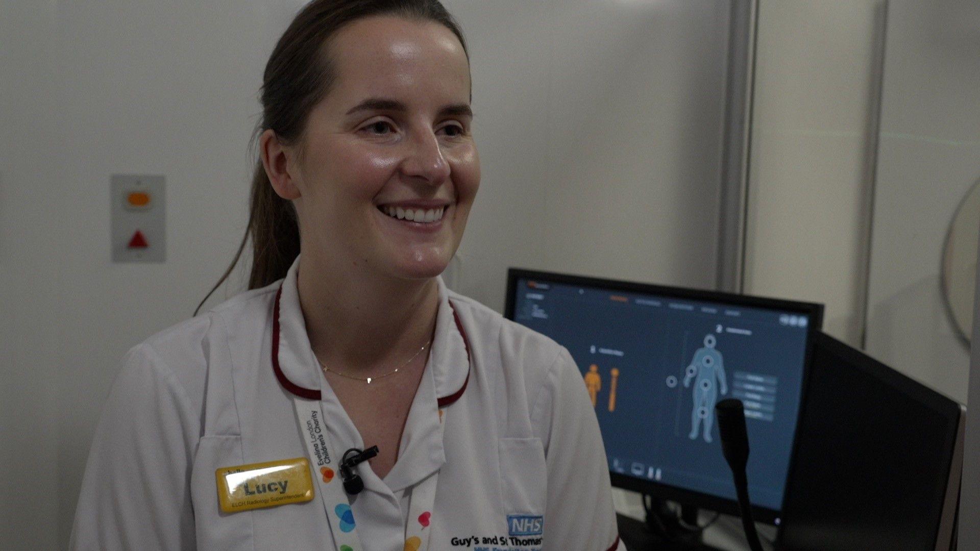 Lucy Clough in her uniform in front of a screen with a person's outline showing. 