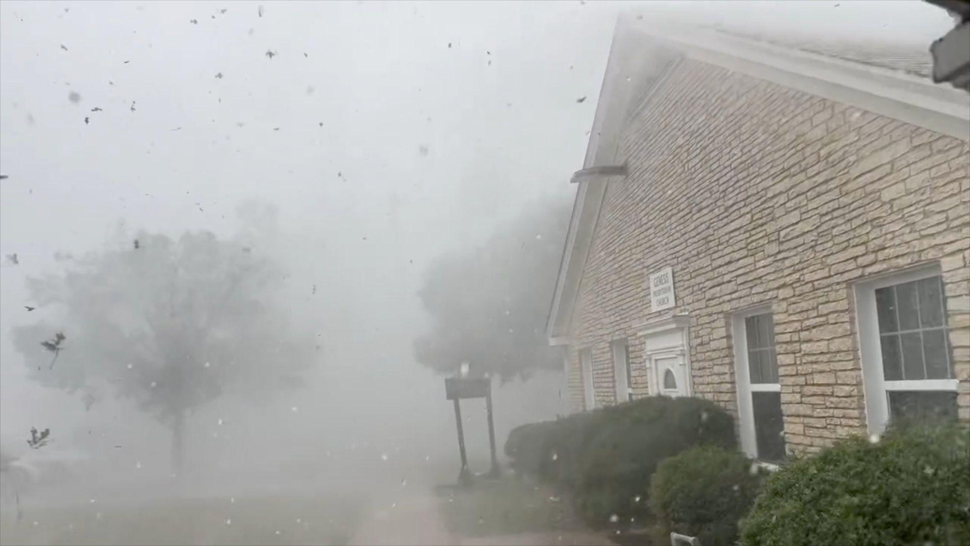 A house surrounded by cloud and debris flying around