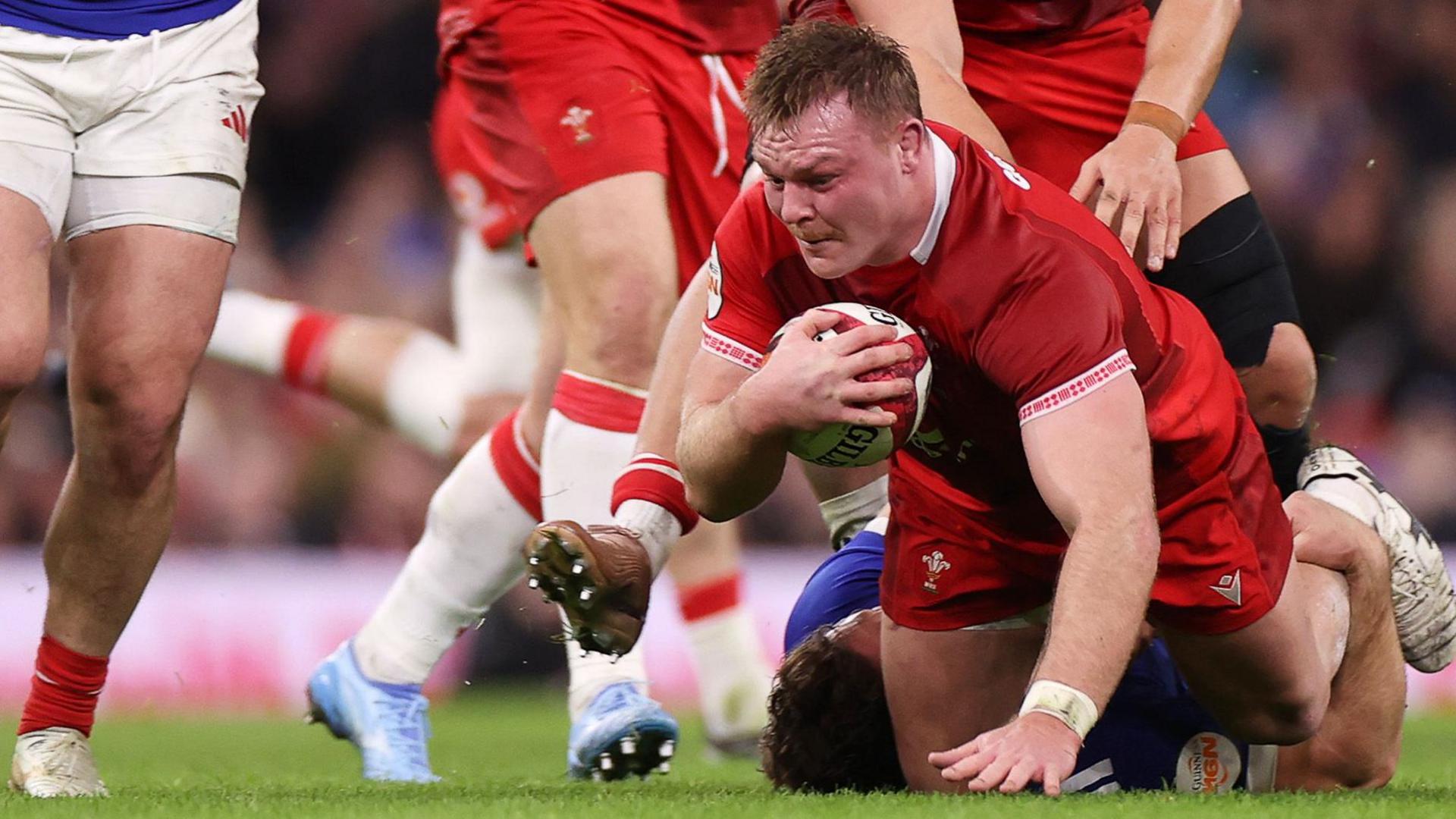Wales captain Dewi Lake in possession of a rugby ball brought to the floor by a French tackle