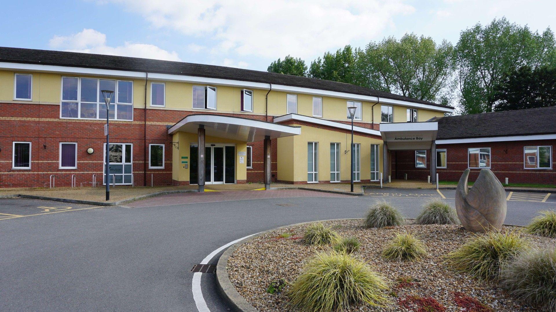 The Coventry Hospice building. It has brick and yellow walls.