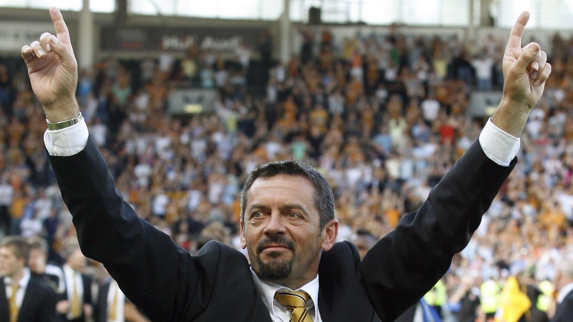 Phil Brown with arms outstretched and pointing to the sky after Hull City escape relegation in May 2009