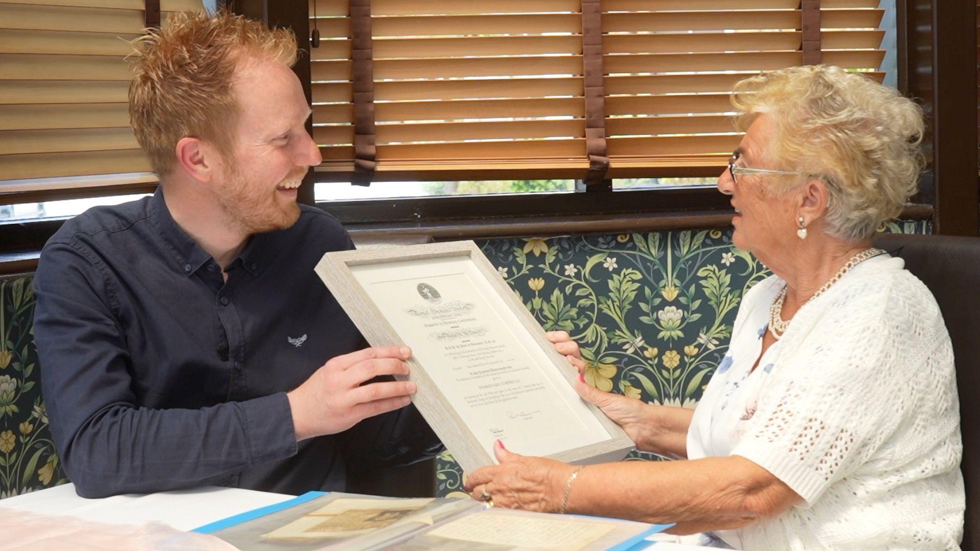 BBC reporter Stuart Woodward presents a certificate to Maureen Roose