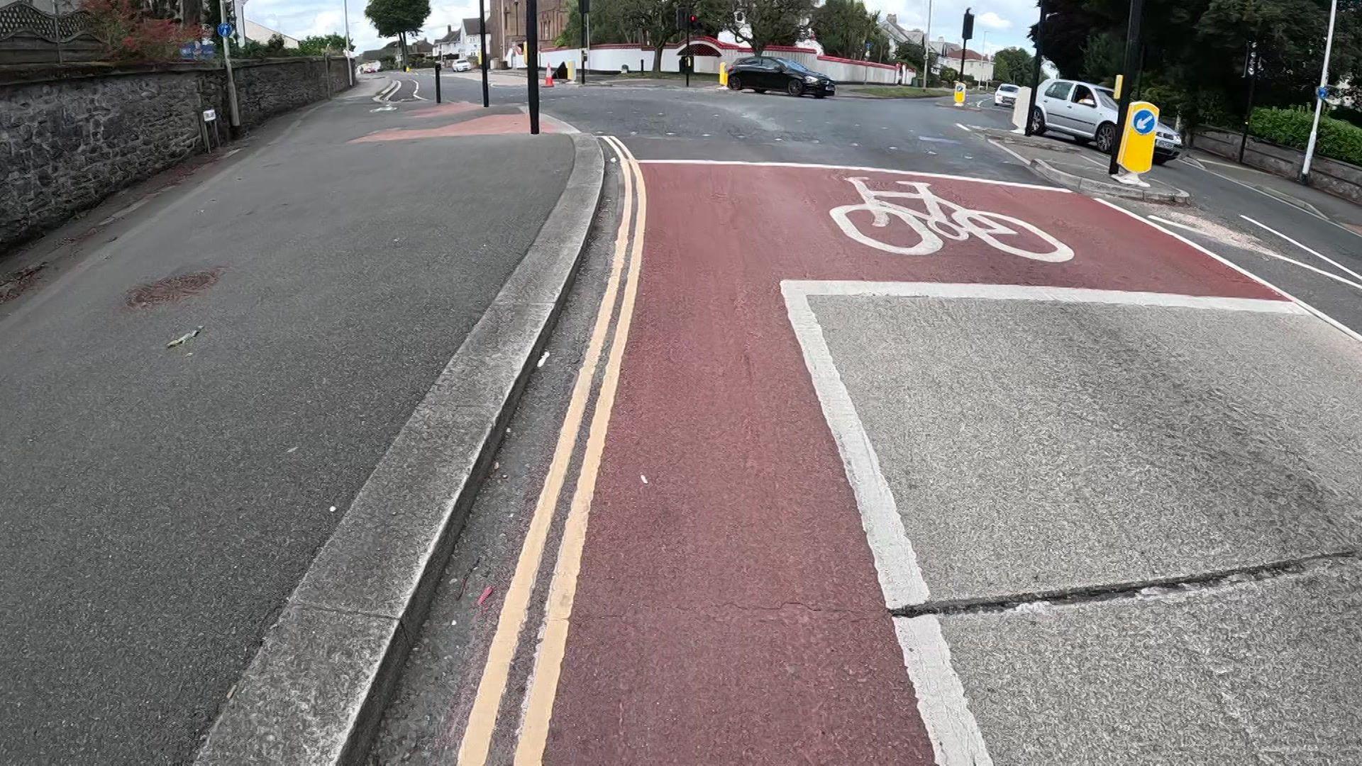 A red-surfaced cycleways at a junction of a major road in Plymouth