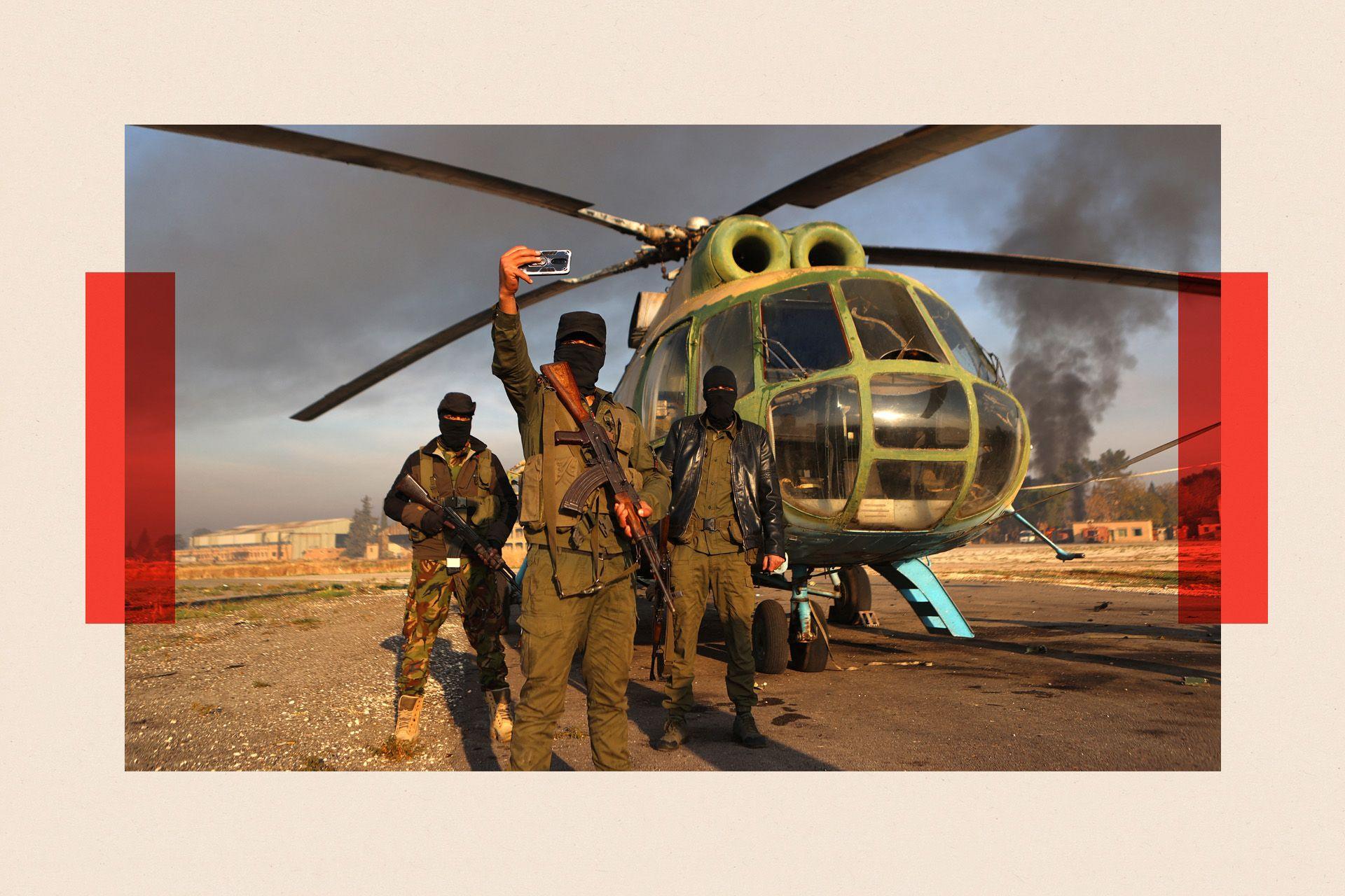 Anti-regime fighters pose for a picture with an army helicopter on the tarmac at the Nayrab military airport in the northern Syrian city of Aleppo in December 2024