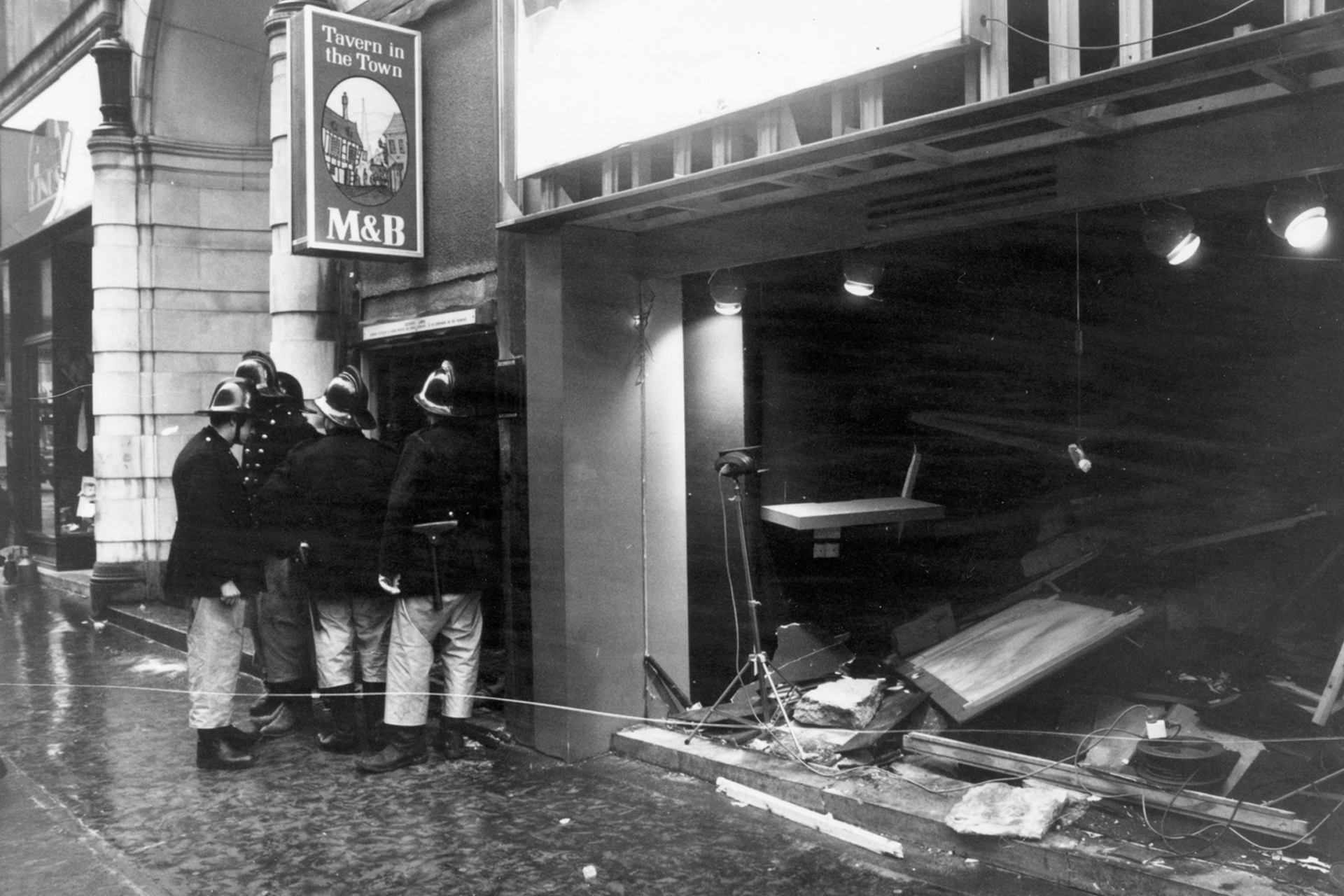 Firemen survey the damage outside the Birmingham pub, Tavern in the Town, after an IRA bomb blast