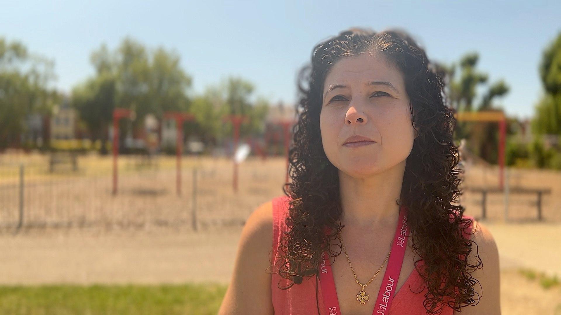 Charlotte Gerada waering a red top, in front of a play park