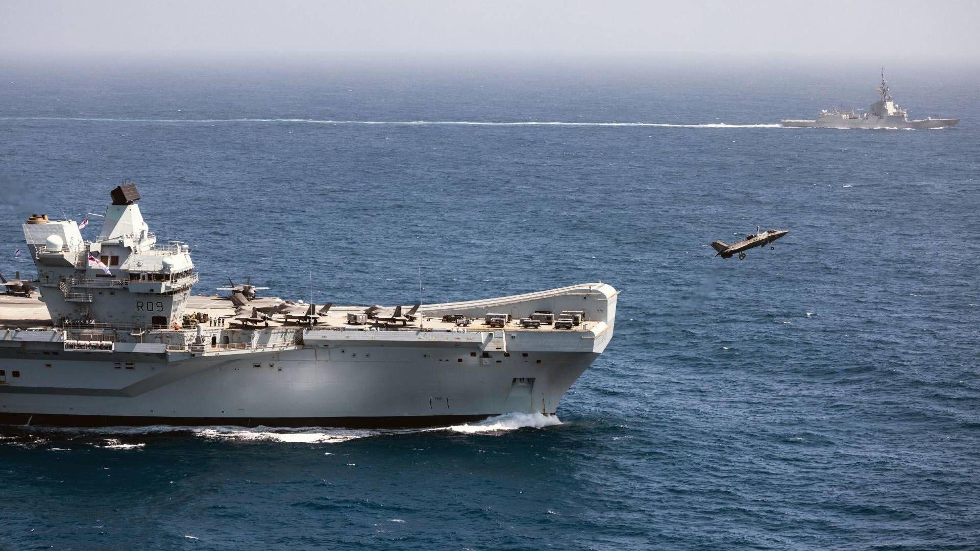 A fight jet takes off from a ship over the open ocean.