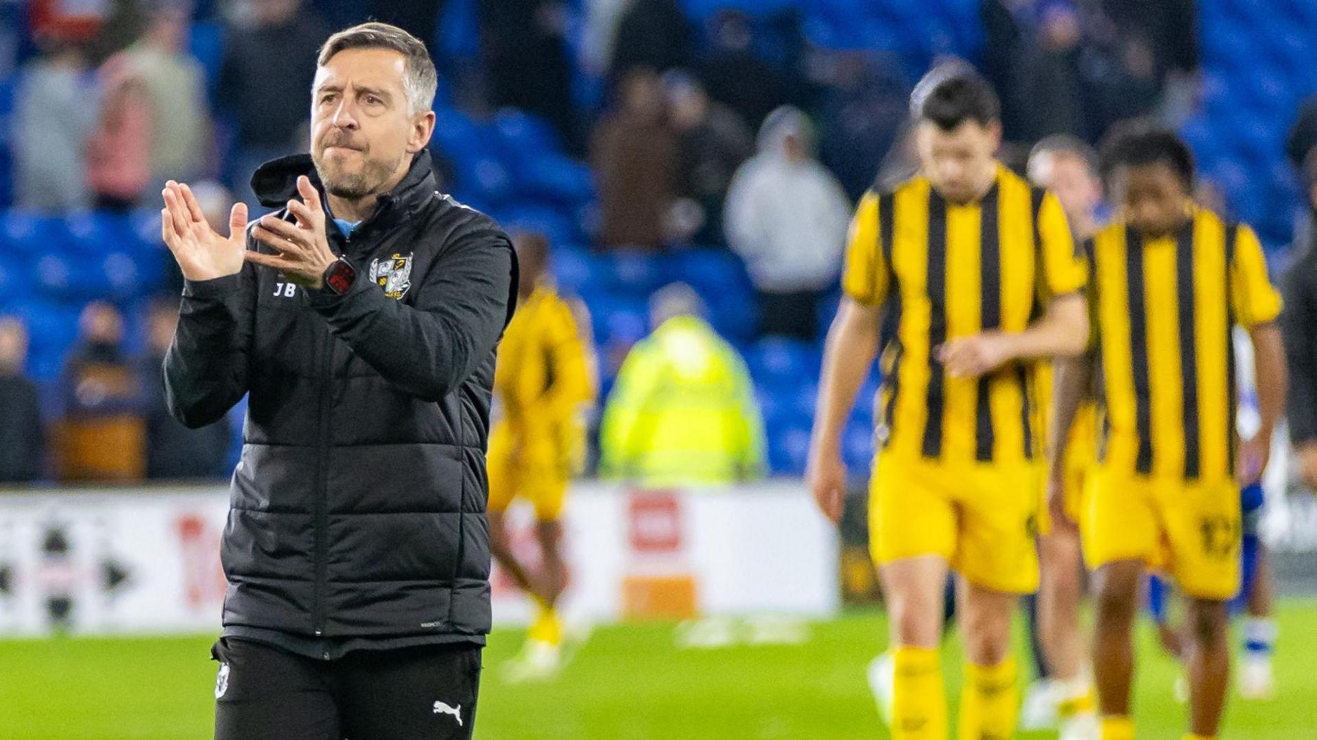 Port Vale manager Jon Brady claps the club's fans at the Cardiff City stadium after their relegation from League One was confirmed