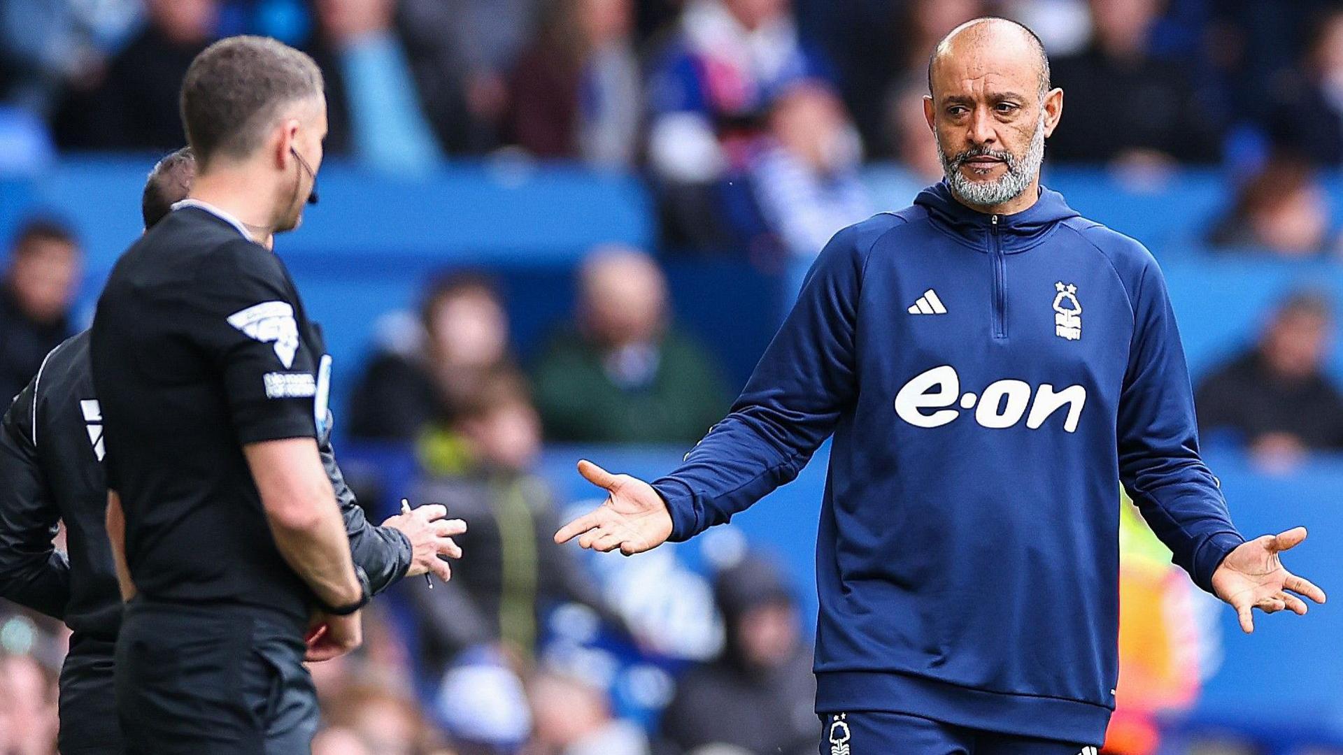 Nuno Espirito Santo, wearing a blue Nottingham Forest tracksuit, gestures to a match official