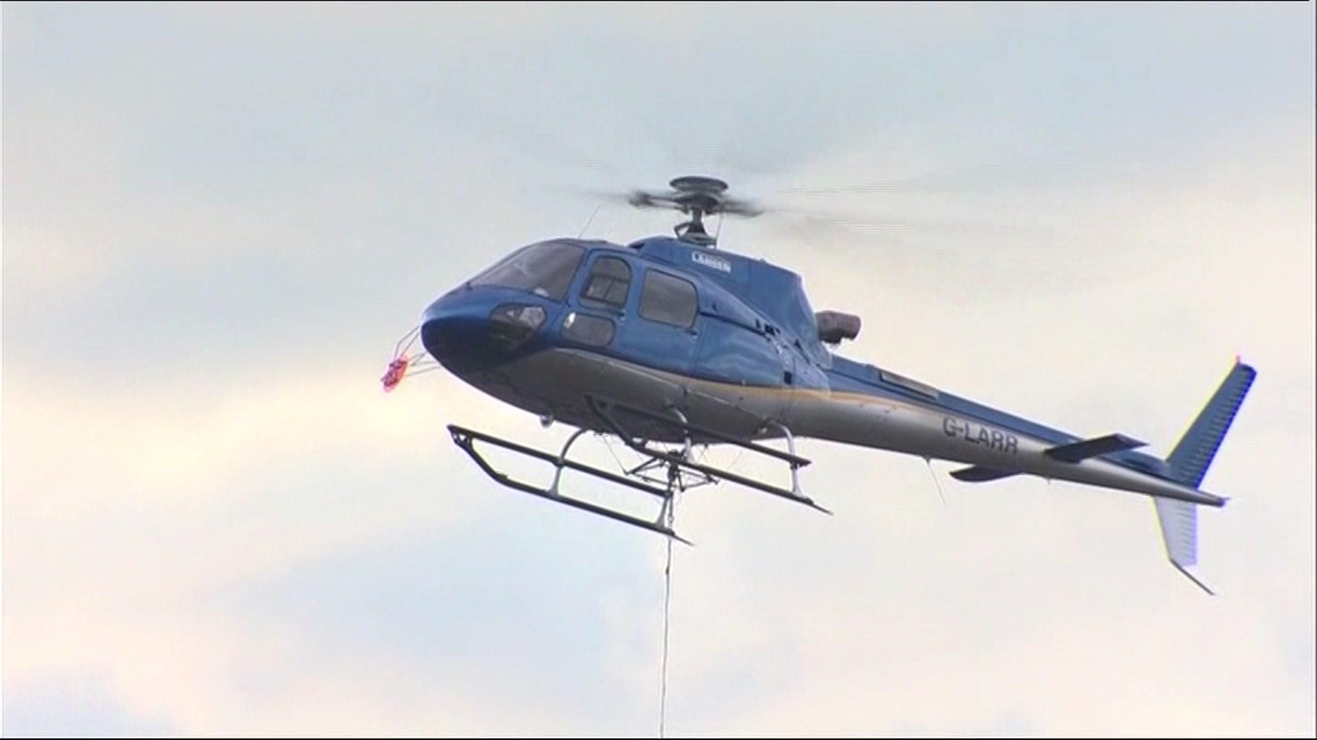 Helicopter carries large bag of fine slate