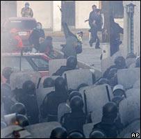 Riot police clash with protesters throwing missiles