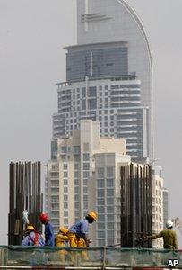 Builders in front of a skyscraper