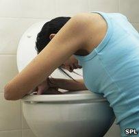 Woman clutching a toilet bowl