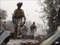 Iraqi soldiers inspect scene of car bomb explosion