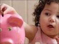 Child putting money in piggy bank
