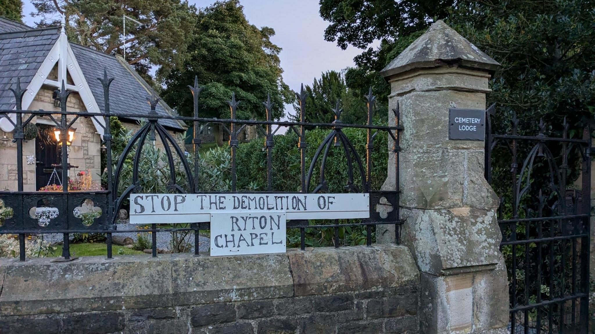 A sign on the fence surrounding Ryton Cemetery reads: "Stop the demolition of Ryton Chapel."