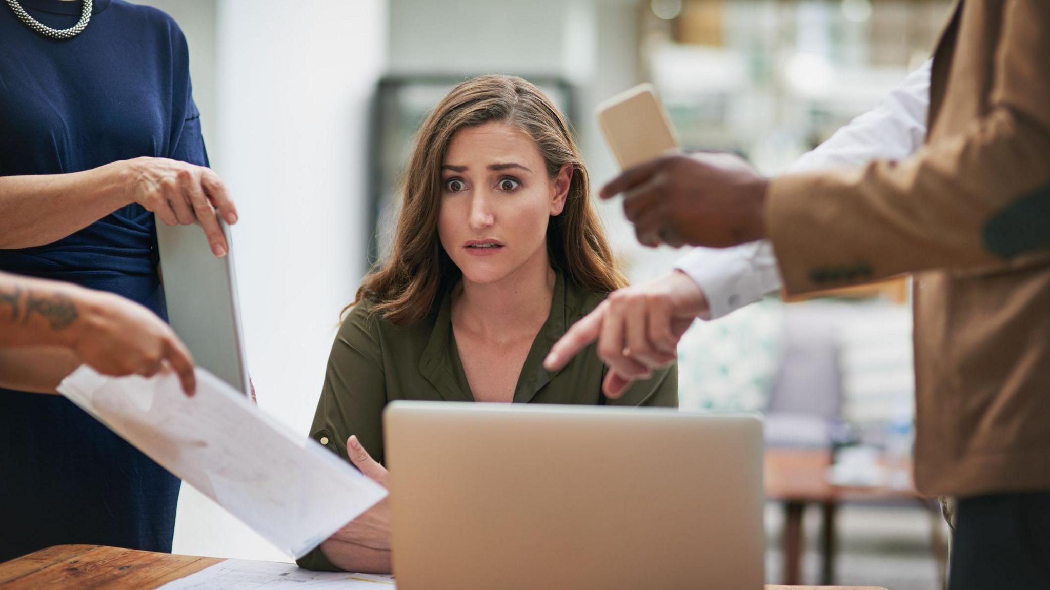 Shot of a young businesswoman looking anxious in a demanding office environment