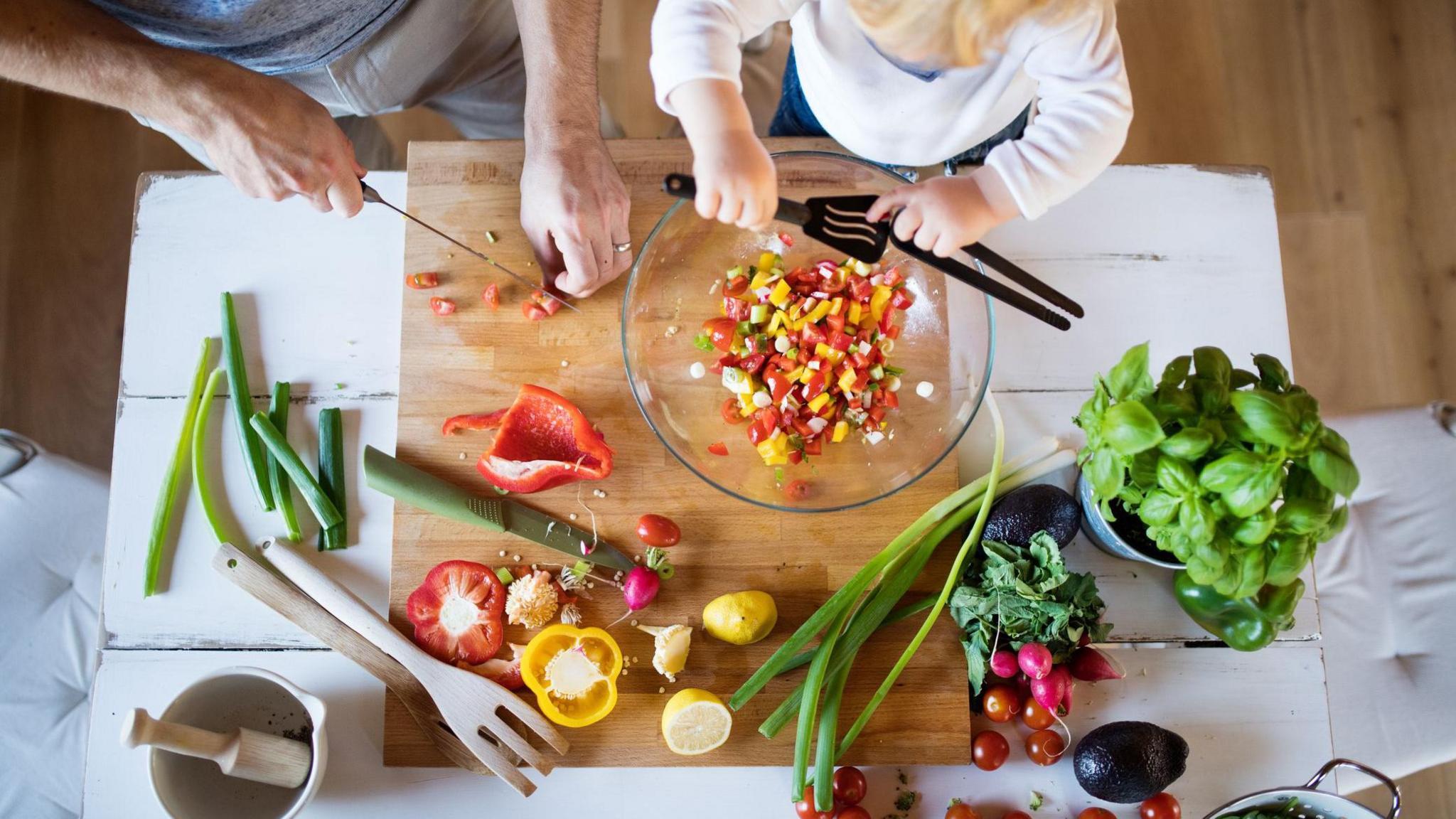 child and parent cooking together