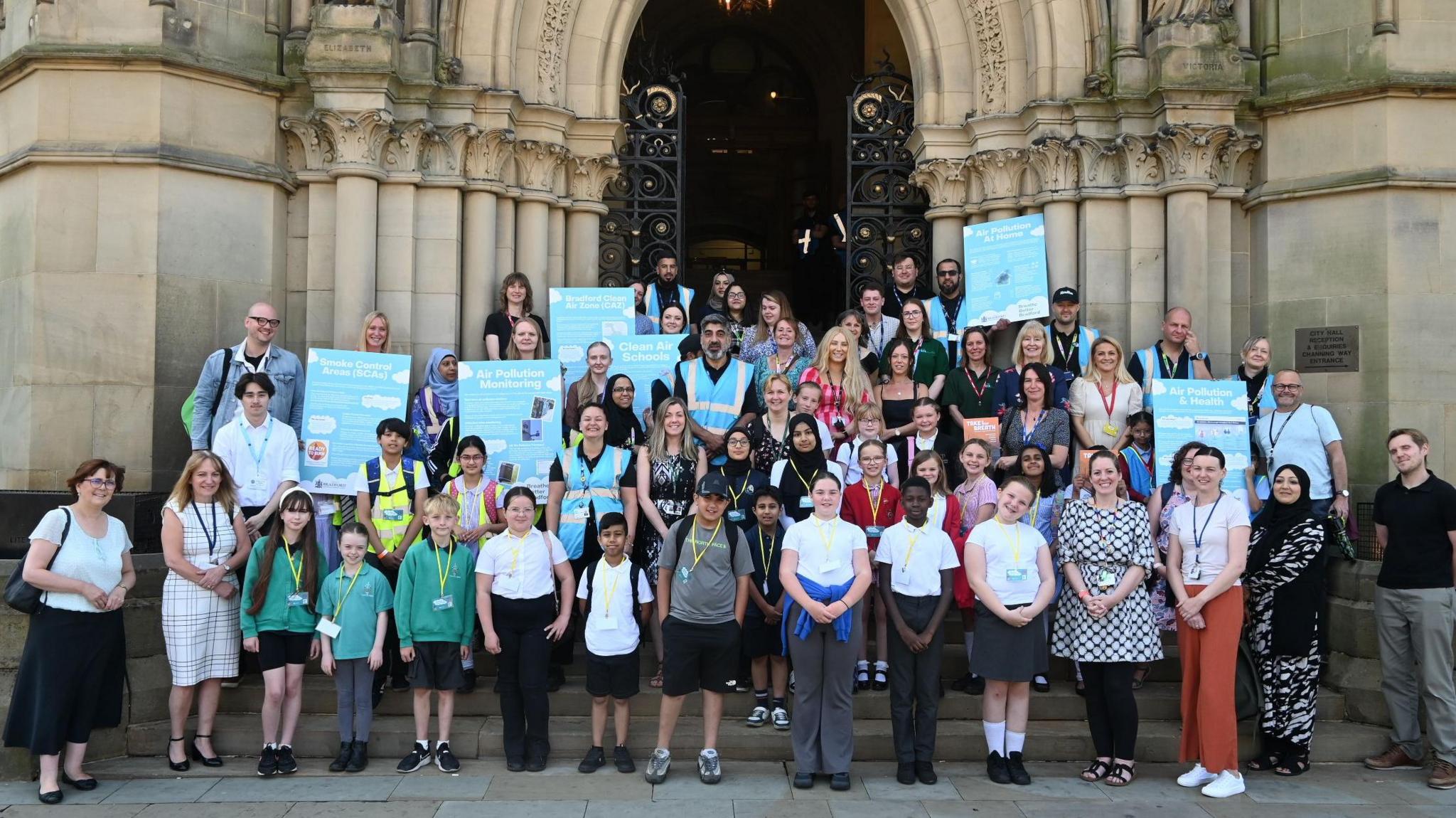 Children and some adults stood outside City Hall with posters about Clean Air Zones