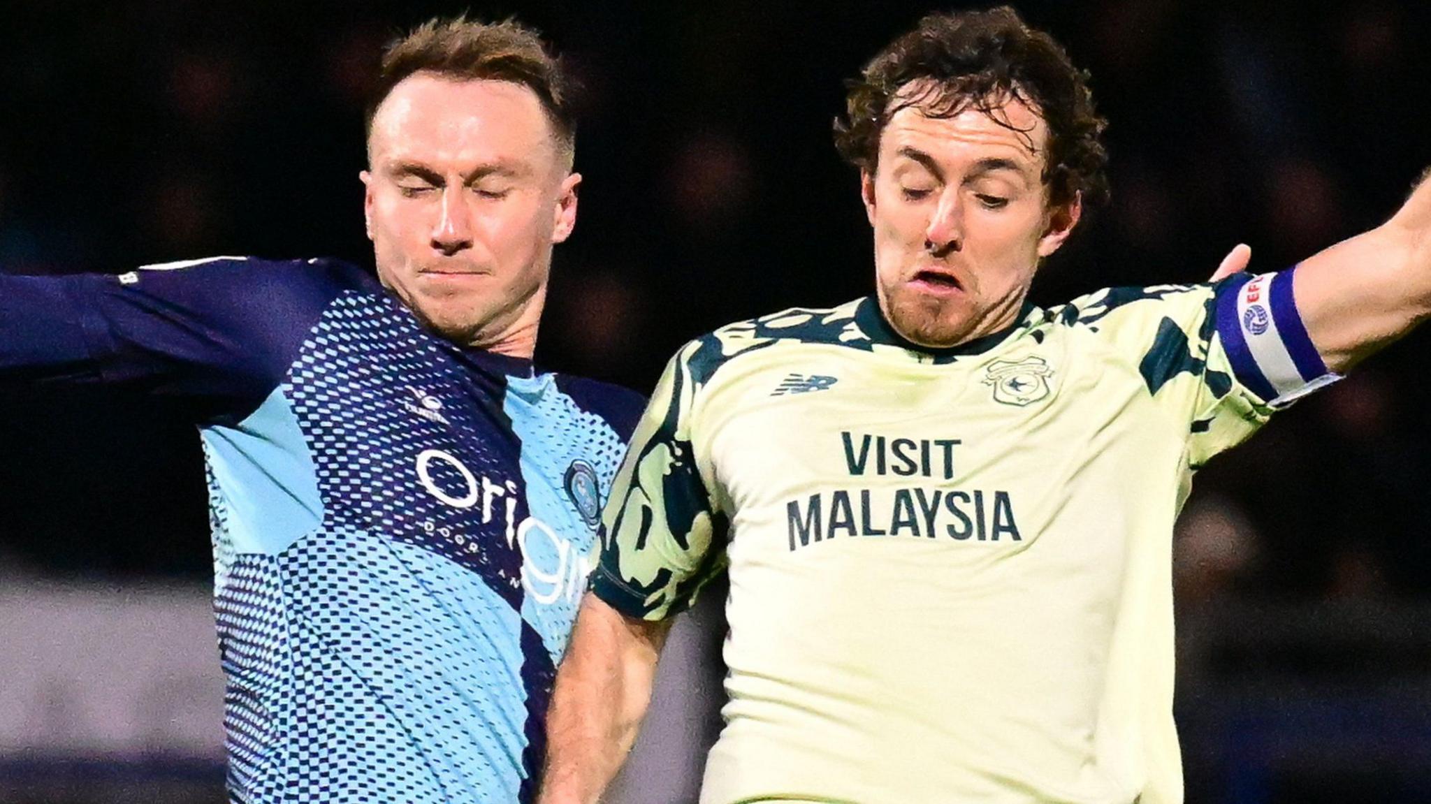 Wycombe Wanderers forward Cauley Woodrow (L) battles for possession with Cardiff City midfielder Ryan Wintle