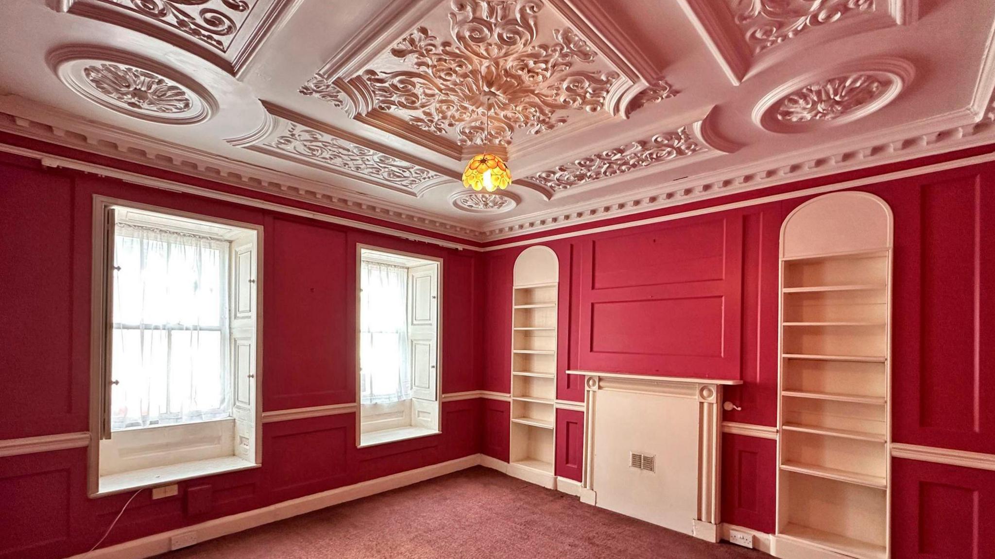  The room has a white decorative ceiling and the panelled walls are painted raspberry.  There are two sash windows to the front each with window 
seat and shutters. 